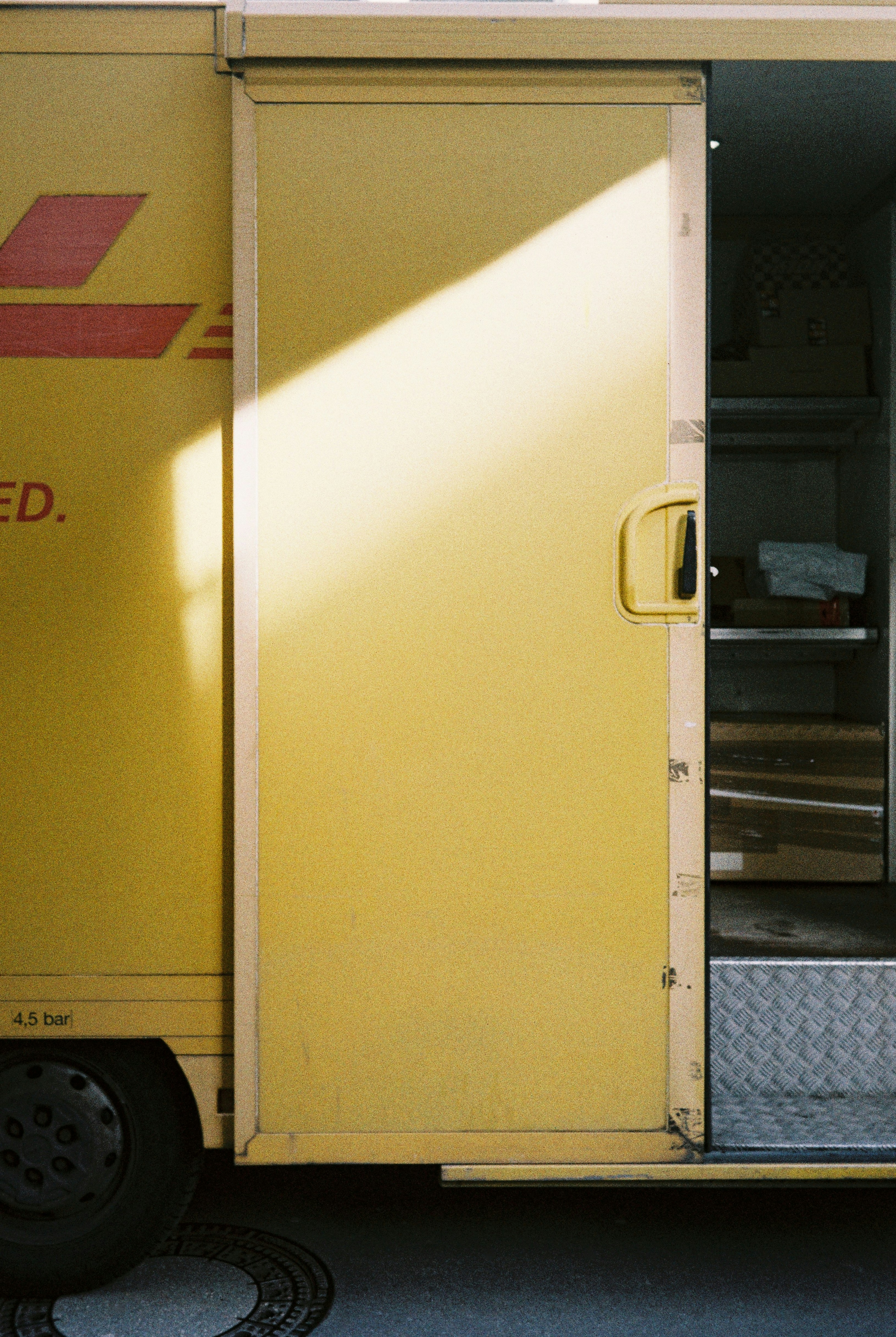 Yellow delivery truck with open door — representing cold chain logistics costs that Thai café operators face when sourcing perishable ingredients